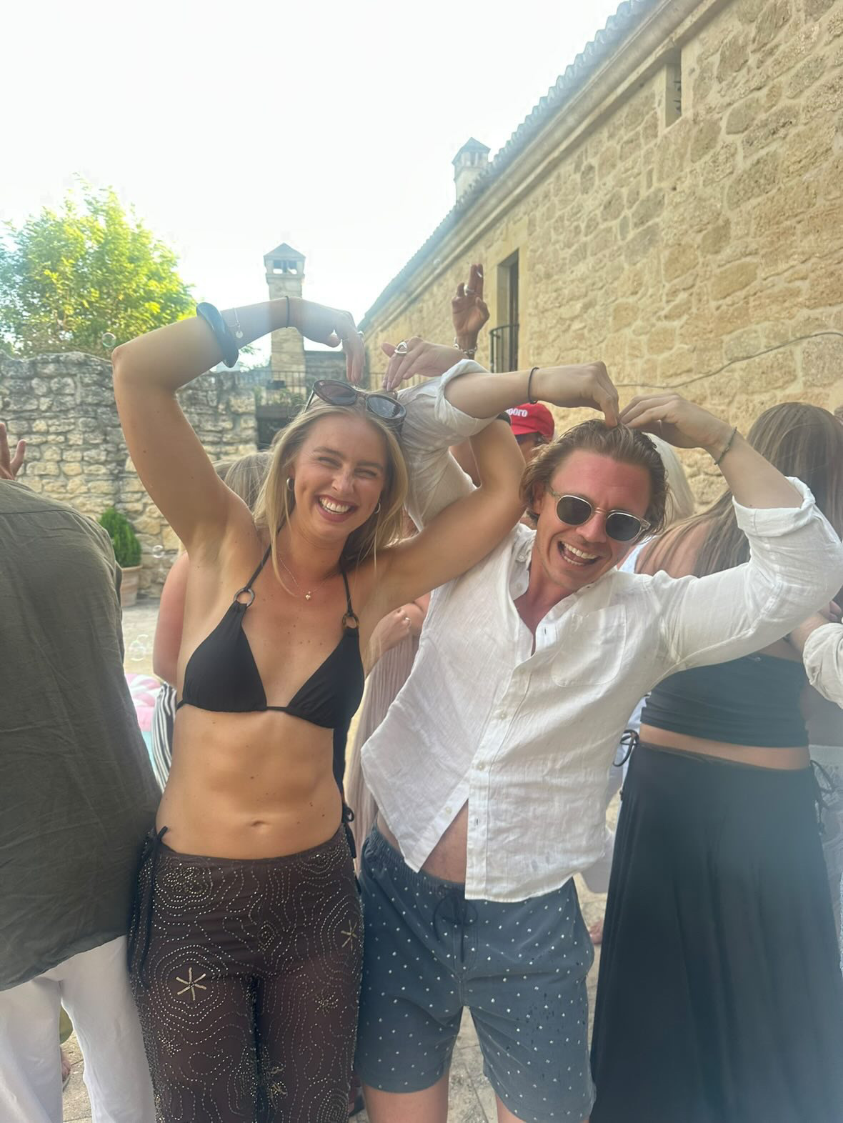 Lovisa och Rutger skrattar och formar ett hjärta med armarna